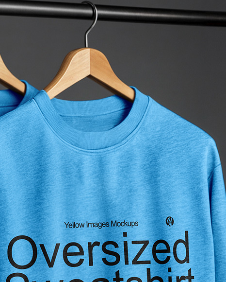 Three Sweatshirts on a Black Rack Against a Plain Background Mockup