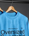Three Sweatshirts on a Black Rack Against a Plain Background Mockup