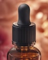 Amber Dropper Bottle with Oil Tincture Surrounded by Flowers Mockup