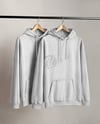 Two Hoodies on a Wooden Hanger Against a Plain Background Mockup