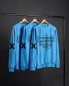 Three Sweatshirts on a Black Rack Against a Plain Background Mockup