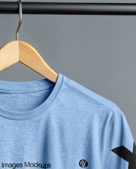 T-Shirt on a Wooden Hanger Against a Plain Background Mockup