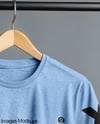 T-Shirt on a Wooden Hanger Against a Plain Background Mockup