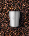 12oz Paper Cup on a Stack of Coffee Beans Mockup