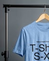 T-Shirt on a Wooden Hanger Against a Plain Background Mockup