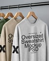 Five Sweatshirts on a Black Rack Against a Plain Background Mockup