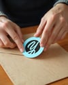 Round Sticker in a Hands Mockup