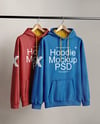 Two Hoodies on a Wooden Hanger Against a Plain Background Mockup