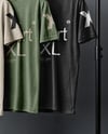 Three T-Shirts on a Wooden Hanger Against a Plain Background Mockup
