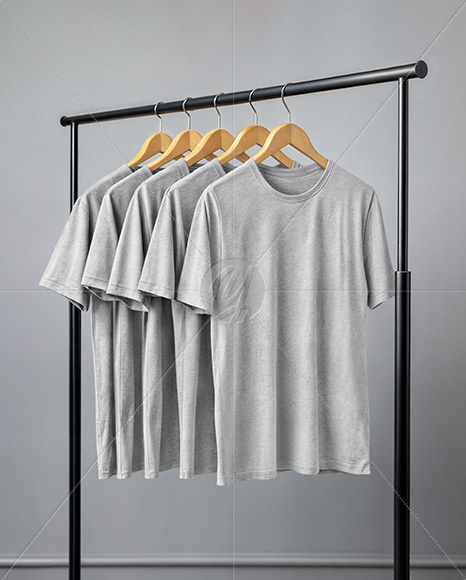Five T-Shirts on a Wooden Hanger Against a Plain Background Mockup