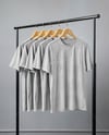 Five T-Shirts on a Wooden Hanger Against a Plain Background Mockup