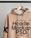 Hoodie on a Wooden Hanger Against a Plain Background Mockup
