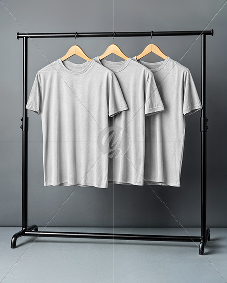 Three T-Shirts on a Wooden Hanger Against a Plain Background Mockup
