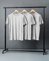 Three T-Shirts on a Wooden Hanger Against a Plain Background Mockup
