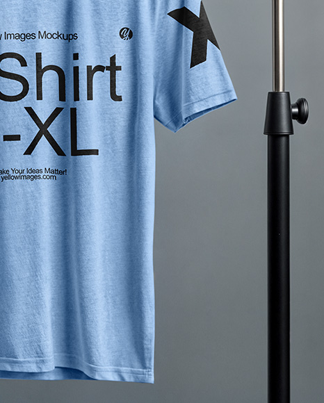 T-Shirt on a Wooden Hanger Against a Plain Background Mockup
