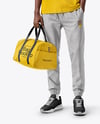 Man Wearing T-Shirt and Sweatpants Holding Duffle Bag Mockup