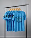 Five T-Shirts on a Wooden Hanger Against a Plain Background Mockup