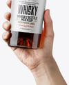 Whisky Bottle in a Hand Mockup