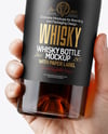 Whisky Bottle in a Hand Mockup