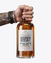 Whisky Bottle in a Hand Mockup